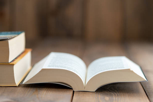 istock A hardback book opened for reading and two large books stacked on the left 1222095976