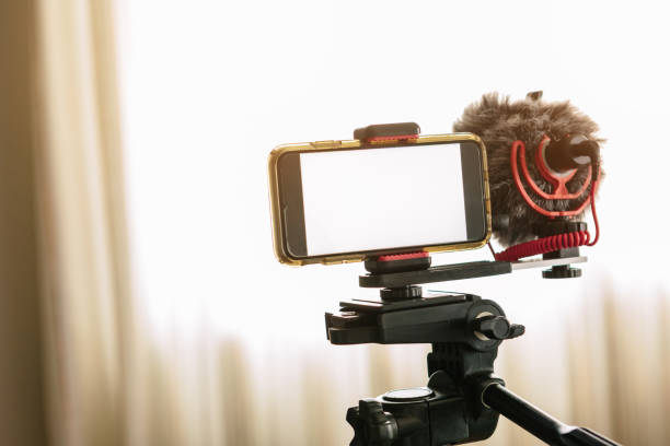 smartphones connected to an external microphone and coupled to a tripod.