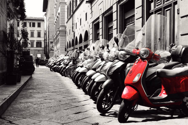 A neatly parked line of Scooters in the streets of Rome.