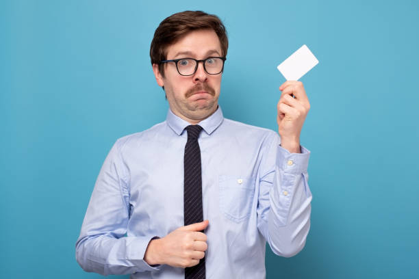 istock Young man holding credit card very scared and afraid hidden 1222097358