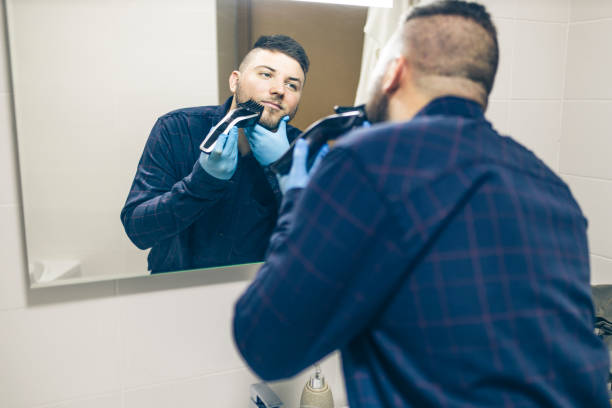 istock Man shaving with electric razor 1222097389