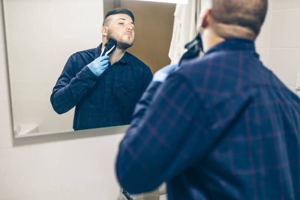 istock Man shaving with electric razor 1222097433