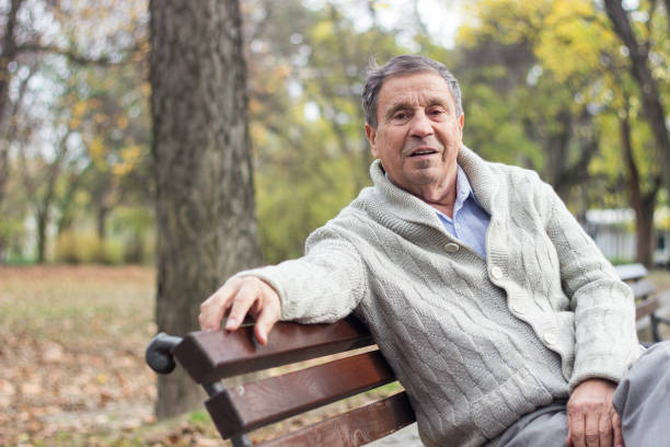 istock Senior man sitting on bench in the park 1222098820