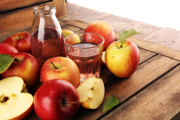 istock Apple cider drink and organic apples with leaves on table 1222100196