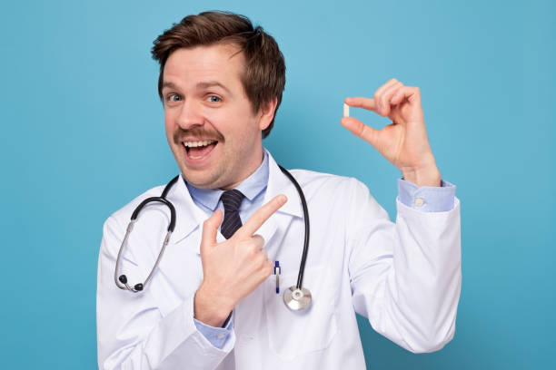 istock Cheerful excited young man with mustache standing and pointing on pills 1222100927