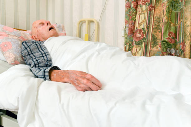 高齢の男性は退院後、ベッドで眠っている。 - 気絶する ストックフォトと画像