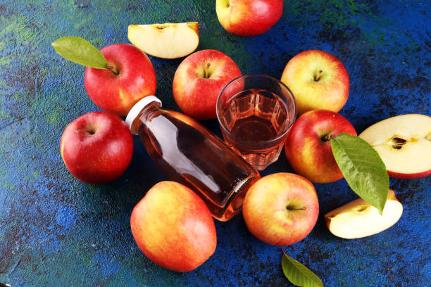 istock Apple cider drink and organic apples with leaves on table 1222101156