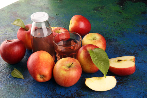 istock Apple cider drink and organic apples with leaves on table 1222101228