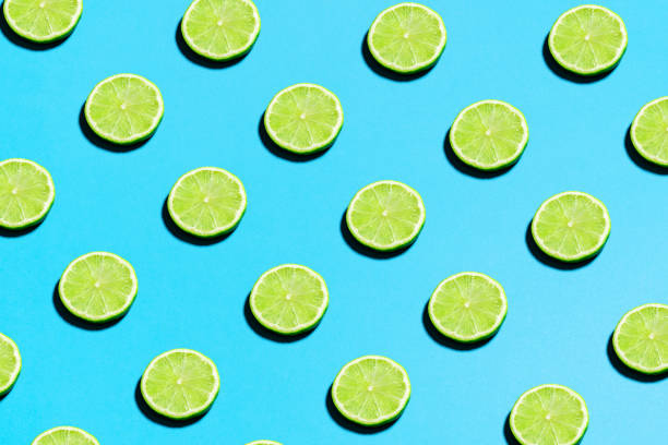istock Lime pattern on bright light blue background. Minimal flat lay food texture. Summer abstract trendy fresh concept 1222101493