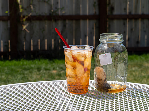 Fresh brewed iced tea, sun tea or sweet tea in the warm sunshine of a summer day.