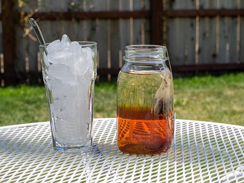 Fresh brewed iced tea, sun tea or sweet tea in the warm sunshine of a summer day.