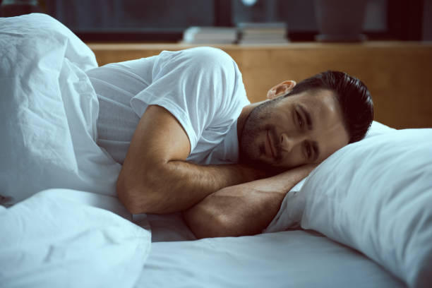 istock Happy young man enjoying morning in bed 1222102385