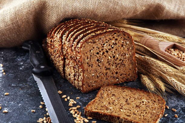 istock Sliced rye bread on cutting board. Whole grain rye bread with seeds on table 1222103496