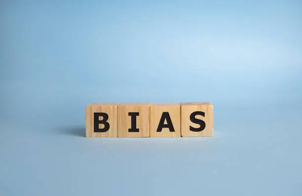Bias - word from wooden blocks with letters, personal opinions prejudice bias concept, blue background.