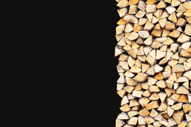 Photo of Woodpile of birch firewood isolated on black background
