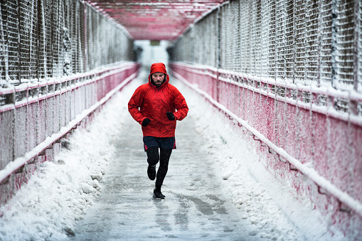 Man running in winter on the Williamsburg bridge in New York