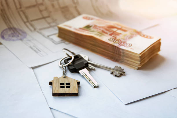 istock A bundle of five thousand notes with keys to an apartment or house on a white background. Buying real estate for Russian money. 1222113602