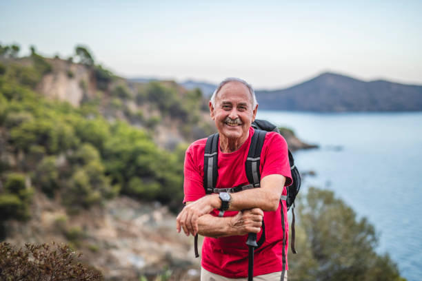 улыбаясь старший мужской день hiker на побережье средиземного моря - spanish and portuguese ethnicity looking at camera waist up outdoors стоковые фото и изображения