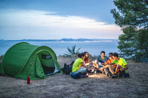 istock Campers Talking and Toasting Sunset on Mediterranean Coast 1222113689