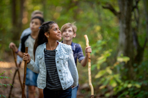 Elementary school kids hiking Diverse group of friends exploring in the forest. field trip stock pictures, royalty-free photos & images