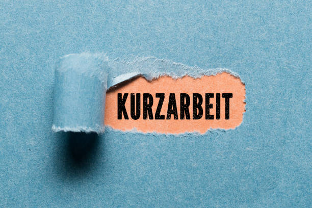 istock torn paper revealing the German text for SHORT TIME WORK 1222115561