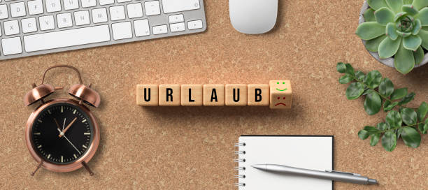 istock cubes with German word for VACATION and happy and sad smiley as answer surrounded by office items 1222116231