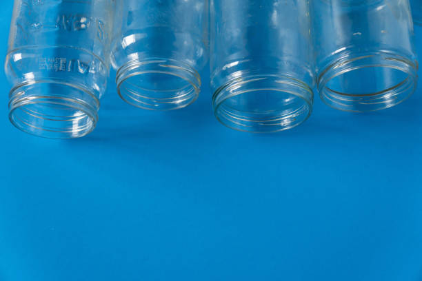 istock 4 several glass jars on an isolated blue background with copyspace or blank empty room space for text or copy. Recyclables for environmental flat lay concept. 1222117155