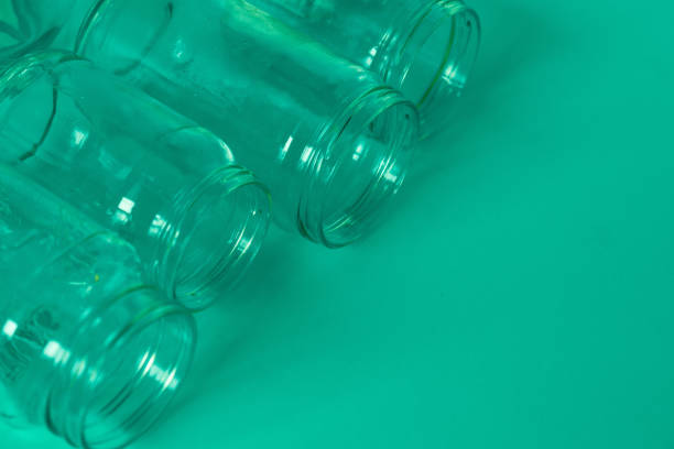 istock 4 several green glass jars on an isolated mint green background with copyspace or blank empty room space for text or copy. Recyclables for environmental flat lay concept. 1222117162
