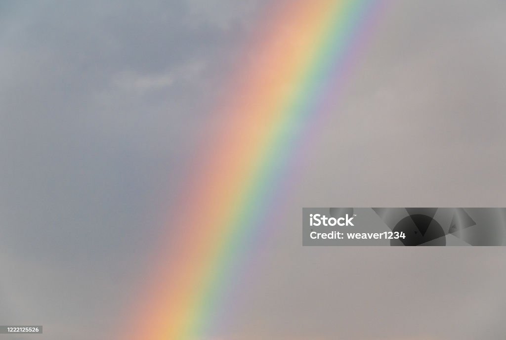 Rainbow in the Sky against the Dark Storm Clouds A beautifully colored rainbow in the sky against the dark storm clouds. Beauty Stock Photo