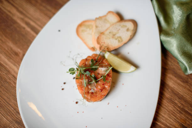 istock salmon tartar with garlic and lime on white dish wooden table 1222126859