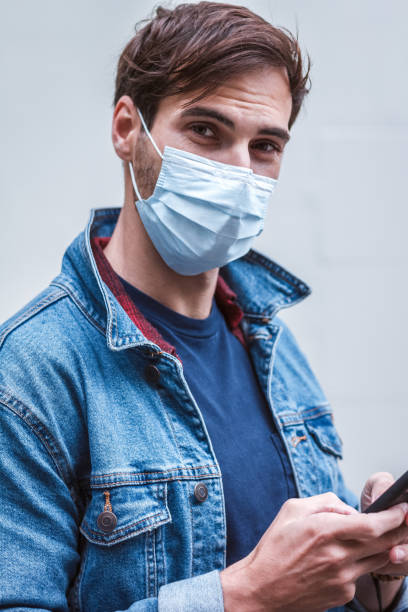 istock Man is wearing a surgical mask and sending a message to someone 1222126860