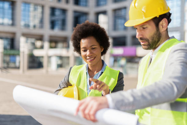 istock Engineers looking at a blueprint of an office building. 1222132210