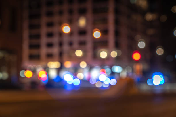 An out of focus cityscape background image of Michigan Avenue in downtown Chicago with red and blue police and ambulance lights at a street corner responding to an emergency blurred in background. stock photo
