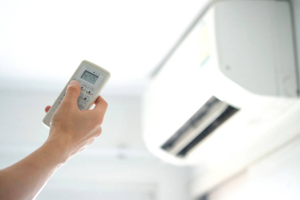 istock Man's hand using remote control open The air conditioner is cooled to 25 degrees Celsius in his bedroom. Health concepts and energy savings 1222135460