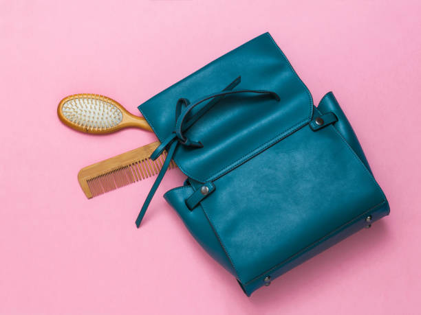 istock Two wooden combs and a leather women's bag on a red background. 1222141940