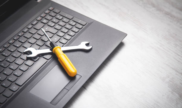 istock Wrench and screwdriver on the computer keyboard. IT Service. Support 1222144689