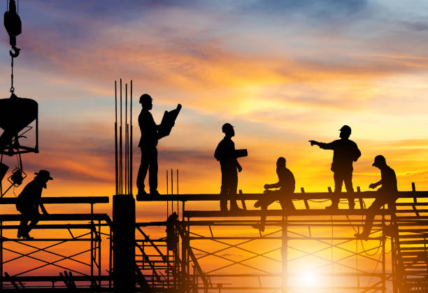 istock Silhouette of Engineer and worker on building site, construction site at sunset in evening time. 1222146301