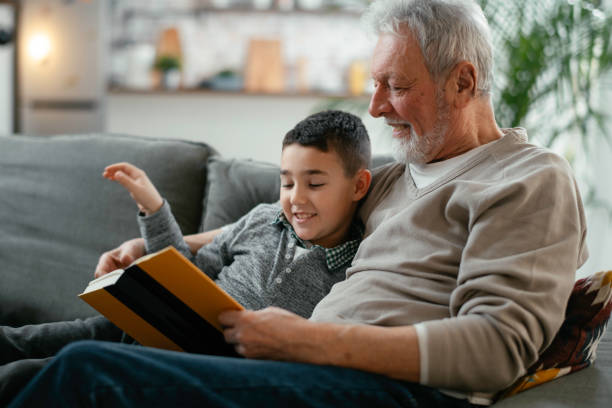 istock Grandpa and grandson reading book together. 1222151261