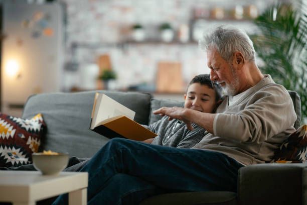 istock Grandpa and grandson reading book together. 1222151285