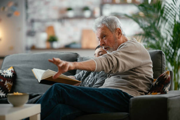 istock Grandpa and grandson reading book together. 1222151304