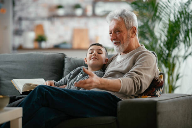 istock Grandpa and grandson reading book together. 1222151382