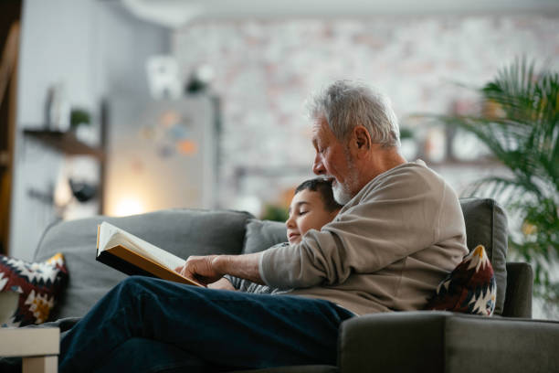 istock Grandpa and grandson reading book together. 1222151403