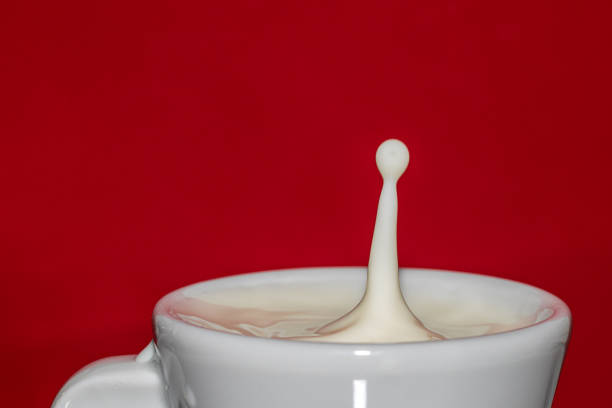 istock drop of milk falling into a cup with red background 1222152811