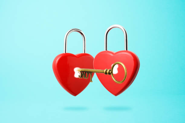 istock Inserting old skeleton key in a red heart shape padlock floating in mid- air. 1222152835