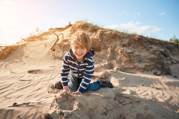 istock Happy boy jumping on sand at sunny day 1222156005