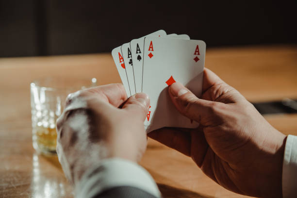 istock Close up of man playing card and drinking whisky. 1222156820