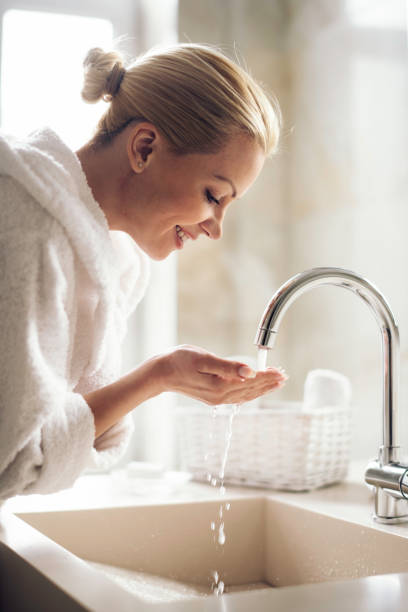 istock Young  happy women in bathrobe wash her face. 1222156961