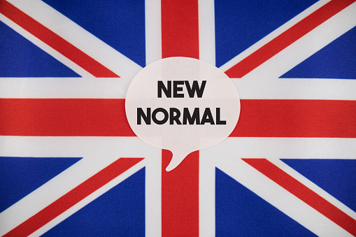 New Normal After Coronavirus. New Normal speech bubble note paper on the British Flag. Horizontal composition with copy space. Global Health and COVID-19 pandemic concept.