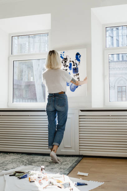 istock Young woman placing abstract paint on the wall 1222158540