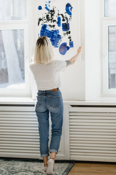 istock Young woman placing abstract paint on the wall 1222158541